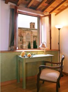 锡耶纳Casacenti B&B的窗户房间里一张桌子和一把椅子