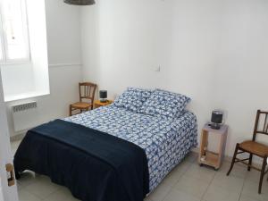 佩里阿克海appartement de la callade的一间卧室配有一张带蓝色毯子的床和两把椅子