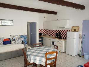 佩里阿克海appartement de la callade的厨房配有桌子、床和冰箱。