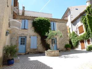 佩里阿克海appartement de la callade的一座古老的石头房子,拥有蓝色的门和树木