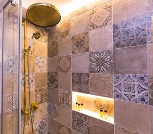 布拉格老城广场布里斯卡公寓的一间带淋浴的浴室和瓷砖墙
