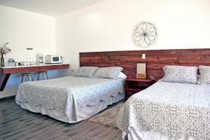 瓜达鲁佩镇Vides del Rio Suites的一间卧室设有两张床和一张带微波炉的桌子。