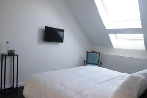 Beauvechainma-tinée的卧室配有一张床,墙上配有电视。