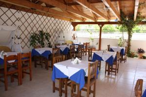 加拉希德松加拉克西迪酒店的餐厅配有桌椅和蓝色餐巾