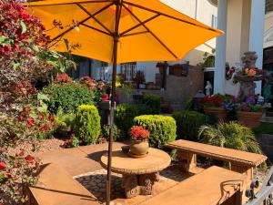 洛杉矶Entire Second Flr - Santa Monica Luxury Roman Villa的花园桌子上摆放着黄伞