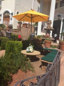 洛杉矶Entire Second Flr - Santa Monica Luxury Roman Villa的一个带桌子和遮阳伞的庭院