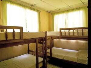 圣萨尔瓦多多纳玛塔住宿加早餐旅馆的带窗户的客房内的三张双层床