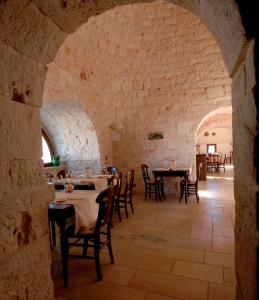 马丁纳弗兰卡玛西丽雅基安科奈托里切拉酒店的石墙内带桌椅的餐厅
