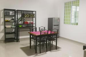 米里HomezStay Airport Miri的厨房配有桌椅和冰箱。