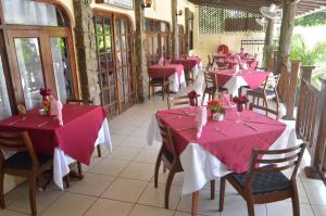 博瓦隆塞舌尔可可多尔酒店的餐厅的一排餐桌,配有粉红色的桌布