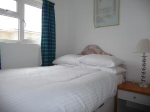 佩伦波斯151 Perran Sands的卧室配有白色的床和窗户