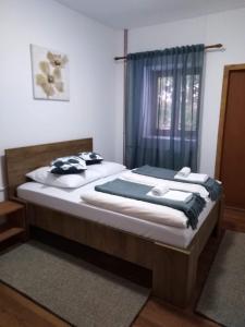 Vrhovine森林球场旅馆的一间卧室设有一张大床和一个窗户。
