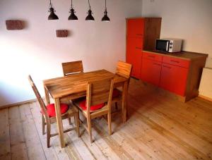 ElmsteinFerienhaus In der Erlebach的厨房配有木桌、椅子和红色橱柜。