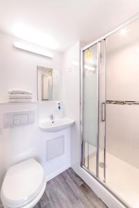 马孔Brit Hotel Macon Nord Autoroute du Soleil的带淋浴和卫生间的白色浴室