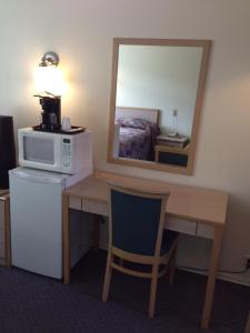 坎卢普斯骑士汽车旅馆的客房设有一张书桌、一台微波炉和镜子