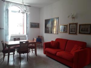 孔韦尔萨诺Casa Arcobaleno的客厅配有红色的沙发和桌子