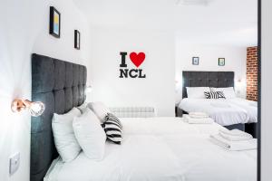 泰恩河畔纽卡斯尔Honeypot House的一间卧室配有两张带白色枕头的床