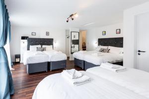 泰恩河畔纽卡斯尔Honeypot House的一间带三张床的卧室,配有白色床单