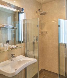 马里纳-迪-皮特拉桑塔滨海酒店的一间带水槽和玻璃淋浴的浴室