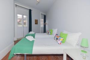 波尔图波尔图御花园公寓的卧室配有带绿色枕头的大型白色床