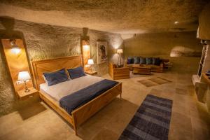 格雷梅Azure Cave Suites - Cappadocia的一间卧室配有一张床和一个沙发