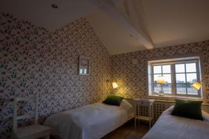 恩雪平Rekasta Bed & Breakfast的一间卧室设有两张床和窗户。