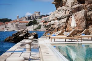 杜布罗夫尼克阿根廷豪华别墅酒店的水边带躺椅的游泳池
