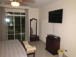 巴兰基亚Stone Creek Barranquilla的一间卧室配有一张床、镜子和电视
