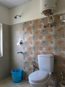 列城海舒克旅馆的浴室配有卫生间,墙上挂有鲜花