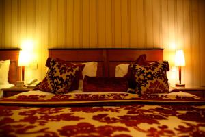 基拉尼锦绣精品酒店的一间卧室配有一张大床和枕头