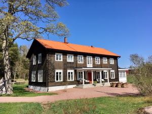 BjörnhuvudBjörnhofvda Gård的一座带橙色屋顶的大型木制房屋
