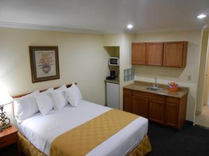 安纳海姆Best Inn & Suites的酒店客房带一张床和一个厨房