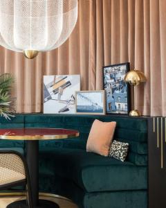 巴黎Hôtel Parisianer的客厅配有绿色沙发和桌子