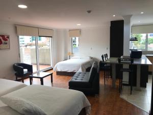 昆卡Gaviota Apartments & Suites的酒店客房带两张床、书桌以及一间客房。