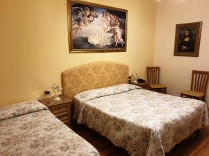 RontaHotel La Rosa的一间卧室设有两张床,墙上挂着一幅画
