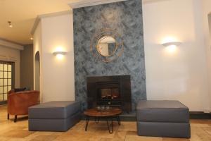 尼芬Gwesty Nanhoron Arms Hotel的客厅设有壁炉和2张凳子
