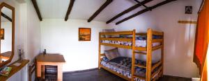 泰托沃Kitka Hostel - Vratnica的客房设有两张双层床和一张书桌。