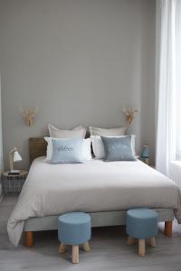拉·寿塞·圣·威Château des Basses Roches的一间卧室配有一张大床和两张蓝色凳子
