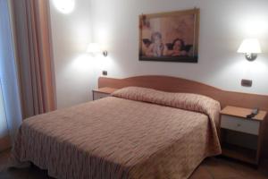 GrammicheleIl Rustico的酒店客房设有一张床,墙上挂着一张照片