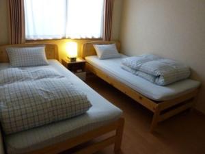 山形市敏太郎小木屋旅馆的小型客房 - 带2张床和窗户