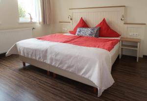 克伦胡森Pension Walmeer的一间卧室配有一张带红色枕头的大床