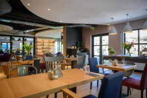 埃因霍温埃因霍温钟楼酒店及餐厅的餐厅设有木桌和蓝色椅子