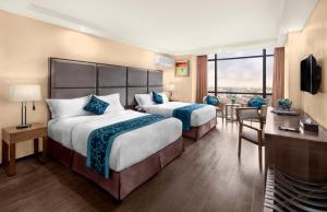 马尼拉Golden Phoenix Hotel - Manila的酒店客房设有两张床和一个阳台。