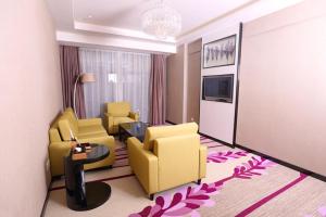 Shunde麗枫酒店·佛山顺德顺联广场店的酒店客房带黄色椅子,起居室。
