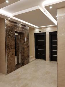 泰布克Waqet AlFakhama Furnished Apartments的客房设有2扇黑色门,铺有瓷砖地板。