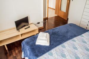 帕尔马New A Casa da Ida的一间卧室配有一张床和一张书桌上的电视
