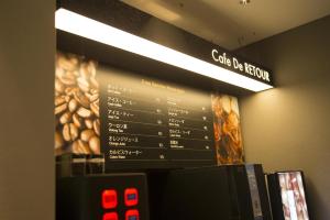 大阪ルトゥール難波 RetourNANBA 男塾ホテルグループ的墙上菜单上的咖啡店标志