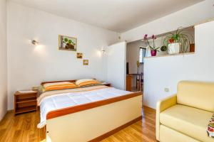 木洛希尼Apartments Gisela, Mali Lošinj的一间卧室配有一张床和一张黄色椅子