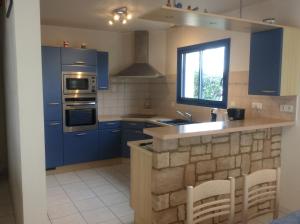 贝诺代Maison près de la Grande Plage的厨房配有蓝色橱柜和台面
