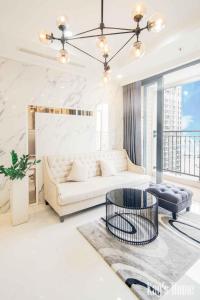 胡志明市Vinhomes Premium Apartment的客厅配有白色的沙发和桌子